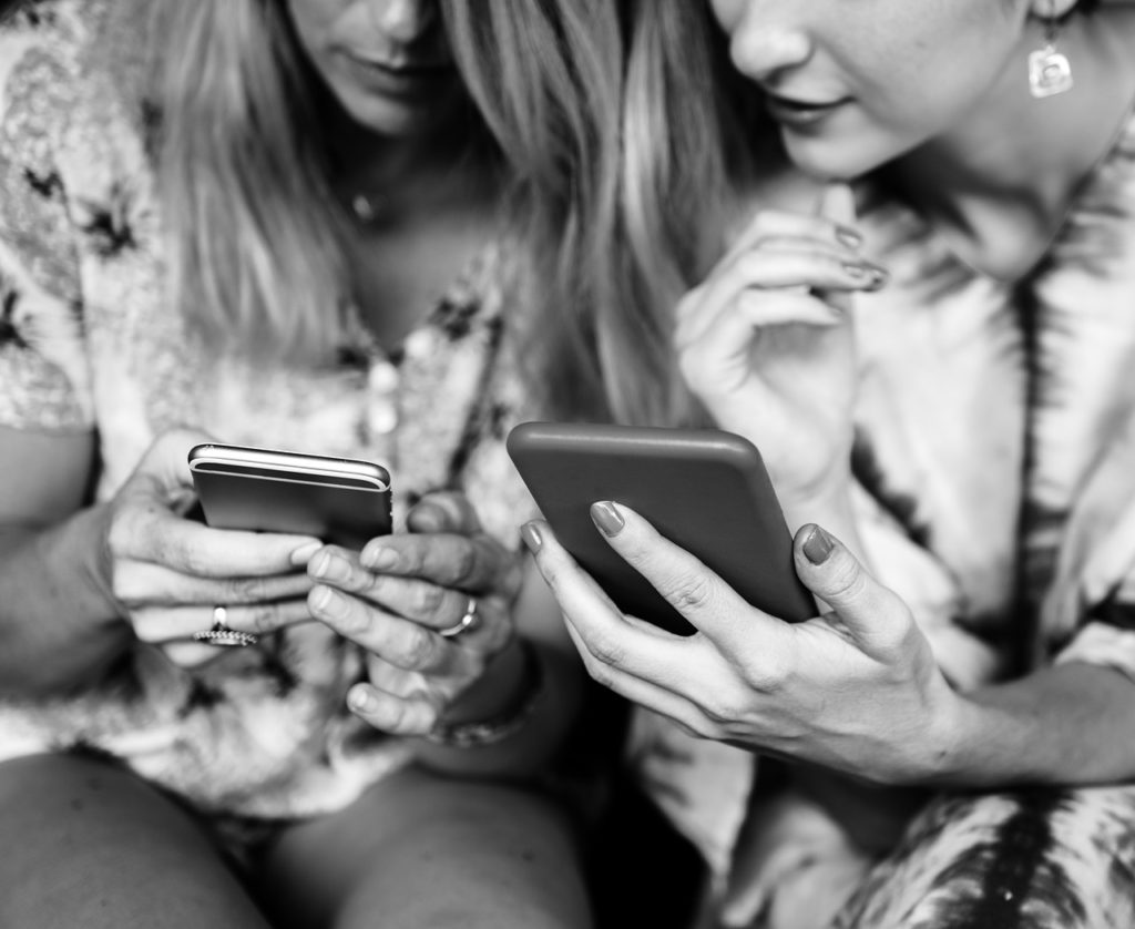 Pic of two girls on mobile phones …used for the blog post entitled: 'Social Media For Business: What You Actually Need to Focus on to Get Results Quickly’.